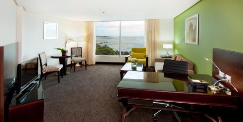 a living room with a couch and a desk and a living room with a view at Crowne Plaza Santo Domingo, an IHG Hotel in Santo Domingo