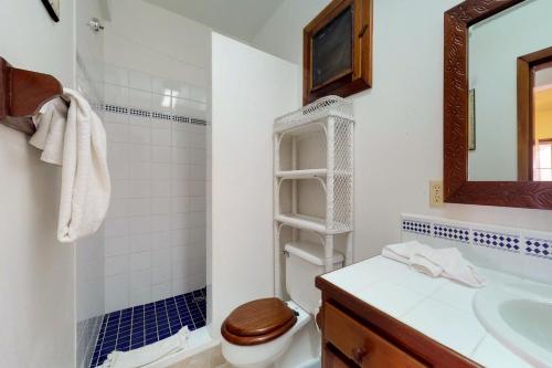 a bathroom with a toilet and a sink and a mirror at Caribe Island Studio #2 in Belize City