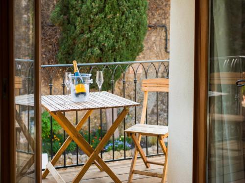- une table en bois avec une bouteille de vin et un verre sur le balcon dans l'établissement Romantic Hideaway Roquebrune-Cap Martin/Monaco near castle, à Roquebrune-Cap-Martin