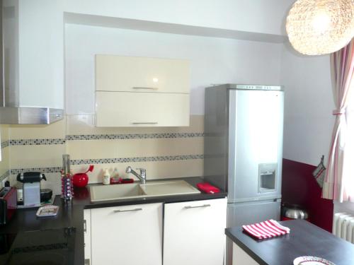 a kitchen with a sink and a refrigerator at Appartement Les Hortensias in Avignon