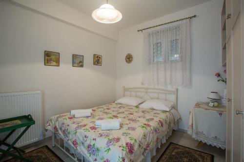 a bedroom with a bed with a floral bedspread at Studios Theodore in Kalamata