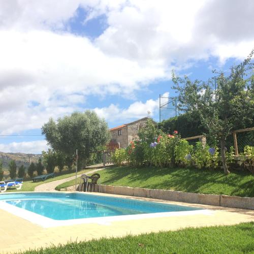 a swimming pool in the yard of a house at Refugio dos Cregos in Riba de Mouro