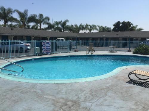 a large swimming pool with blue water in a yard at Frontier Motel in Anaheim