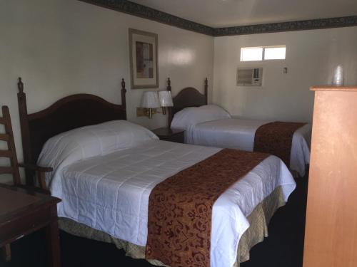 a hotel room with two beds in a room at Frontier Motel in Anaheim