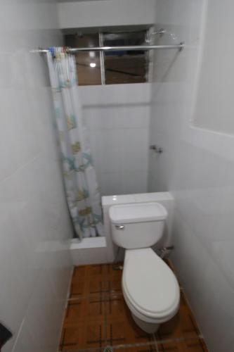 a small bathroom with a toilet and a window at Machu Picchu Land in Machu Picchu