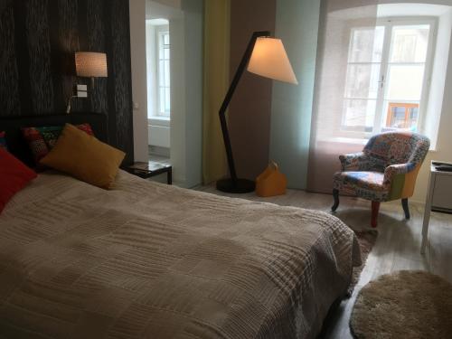 a bedroom with a bed and a chair and a lamp at New flat in old town+garage in Steyr