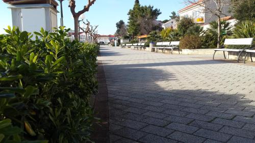 a sidewalk with benches and trees in a park at Apartments Adriatic 2 in Selce