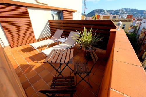 a balcony with a bench and chairs on a building at Hotel Carmen in Roses