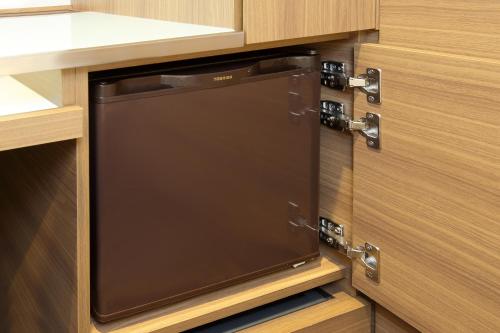 a dishwasher in a kitchen with wooden cabinets at Keio Presso Inn Hamamatsucho in Tokyo