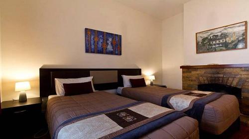 a hotel room with two beds and a fireplace at Brockworth Cottage in Christchurch