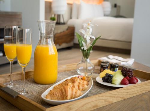 Nobu Hotel Miami Beach في ميامي بيتش: صينية مع كأسين من عصير البرتقال وصحن من الطعام
