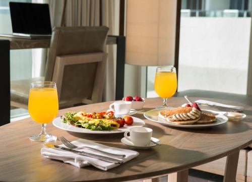 Nobu Hotel Miami Beach في ميامي بيتش: طاولة بها طبقين من الطعام وكوبين من عصير البرتقال