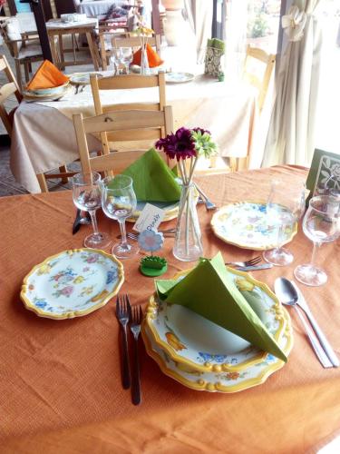 a table with plates and utensils on a table at B&B Villa del Sole Relais in Agrigento