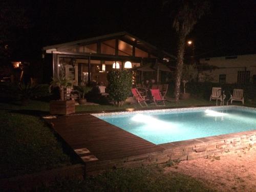a swimming pool in front of a house at night at Casa dos Amigos - A luxury home in the nature in Torreira
