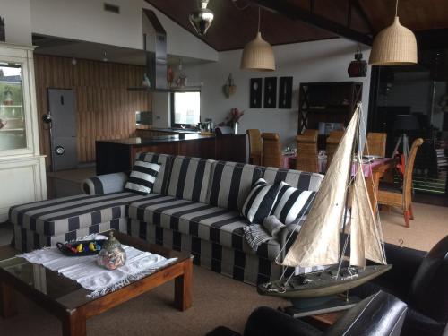a living room with a couch and a model boat on a table at Casa dos Amigos - A luxury home in the nature in Torreira