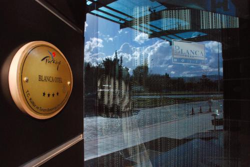 a window with a sign on the door of a restaurant at Blanca Hotel in Izmir
