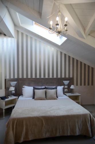 a bedroom with a large bed with striped walls at Hotel Giulio Cesare in Turin