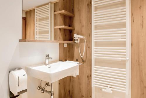 a bathroom with a white sink and a toilet at Alpengasthof Zollwirt in Sankt Jakob in Defereggen