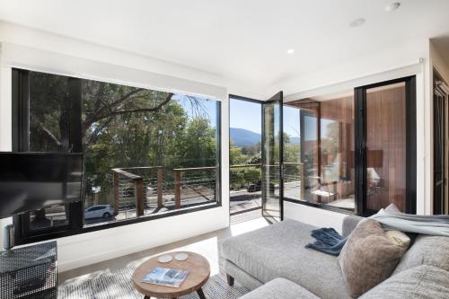 a living room with a couch and a large window at Brooklands Apartments in Healesville