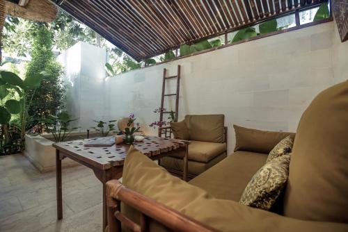 een patio met een tafel en stoelen bij Karmagali Suites Adults only & Private Pool Family Villas in Sanur