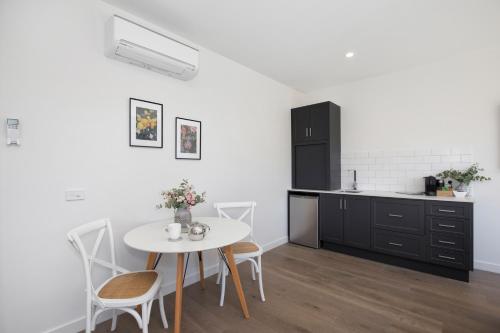 a kitchen with a table and chairs in a room at Brooklands Apartments in Healesville