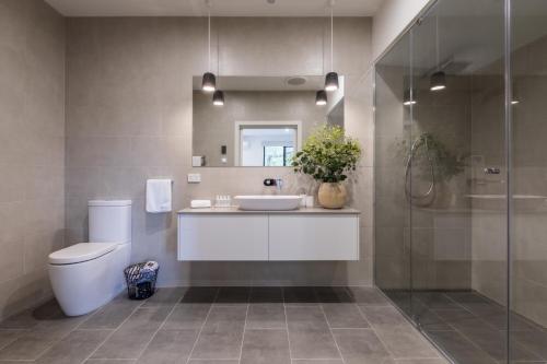 a bathroom with a toilet and a sink and a shower at Brooklands Apartments in Healesville