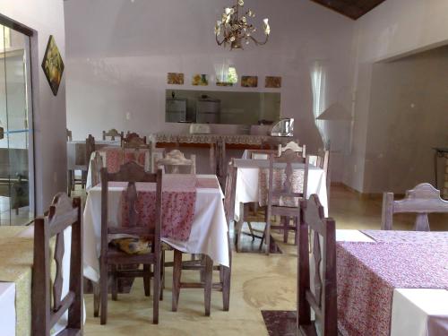 a dining room with tables and chairs and a chandelier at Pousada Trilha Violeta in Sao Jorge