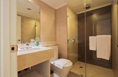 uma casa de banho com um lavatório, um WC e um chuveiro em The B Hotel Alabang em Manila