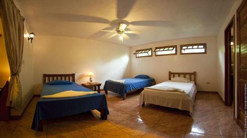 een slaapkamer met 2 bedden en een plafondventilator bij Casitas Joanna in Puerto Viejo