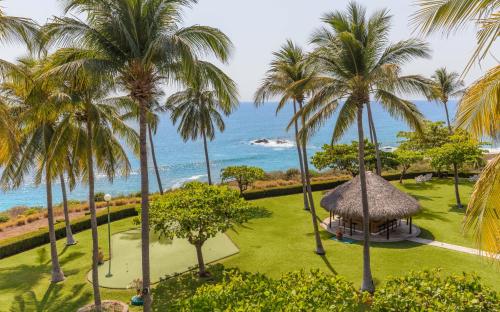 an aerial view of a resort with palm trees and the ocean at Posada Real Puerto Escondido in Puerto Escondido
