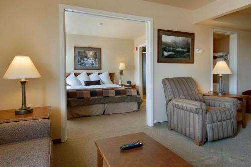 a hotel room with a bed and a chair at Wingate by Wyndham Denver Tech Center in Greenwood Village