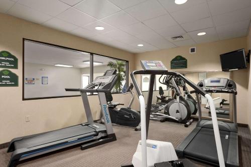 a gym with two tread machines and a mirror at Wingate by Wyndham Pueblo in Pueblo