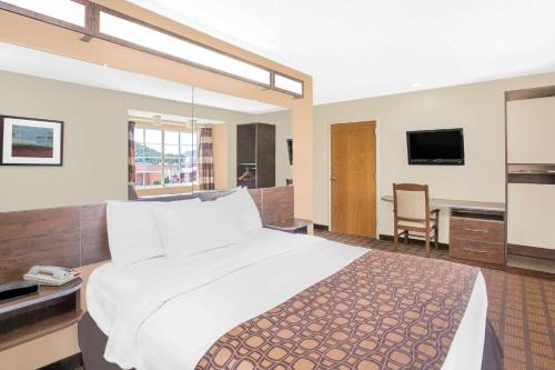 a hotel room with a large bed and a television at Microtel Inn & Suites by Wyndham Franklin in Franklin