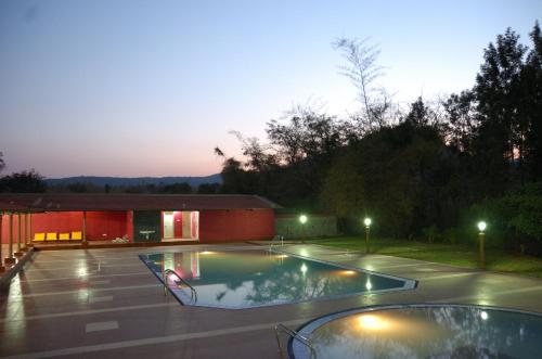 a swimming pool in the middle of a yard at night at MC Resort Wildlife Resort Bandipur in Bandipūr