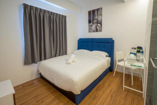 a small bedroom with a blue bed and a window at My Sj Hotel in Subang Jaya