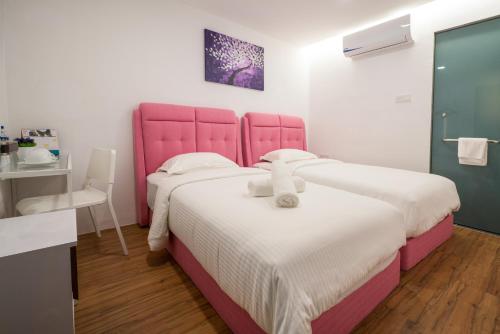 a pink bed with a teddy bear on top of it at My Sj Hotel in Subang Jaya