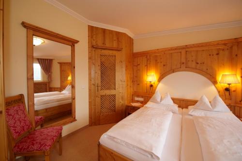 a hotel room with a bed and a mirror at Hotel Ennstalerhof in Ramsau am Dachstein