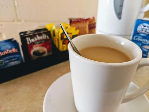 uma chávena de café com uma colher na mesa em Sail Inn Motel em Yeppoon