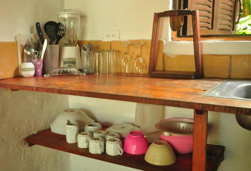 una estantería de madera con tazas y utensilios. en Howler Monkey Hotel, en Montezuma