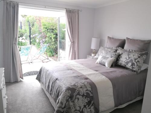 a bedroom with a large bed and a sliding glass door at Terra Nostra in Mapua