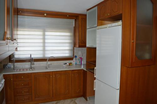 a kitchen with a white refrigerator and a sink at Ionian Sea Base Floor Villa Apartment at Kyllini in Kástro Tornéze