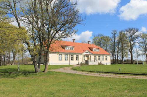 a large white house with an orange roof at Loona Manor Guesthouse in Kihelkonna