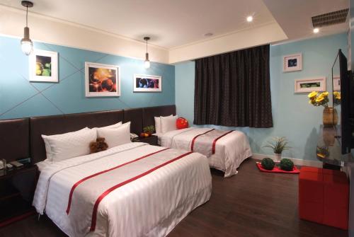 two beds in a hotel room with blue walls at Cai-Lai Motel in Yangmei