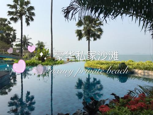 a picture of a pool at a resort with the words happy pineapple beach at The palm wongamat pattaya in North Pattaya