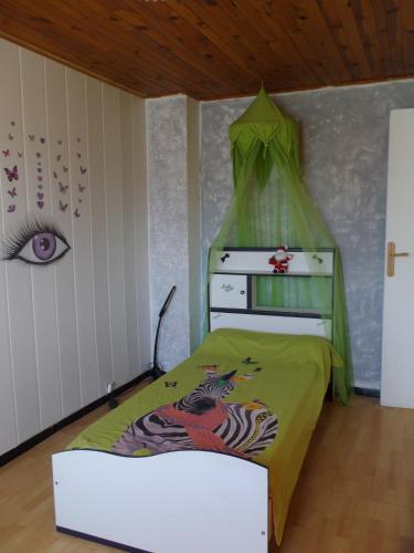 Cette petite chambre comprend un lit avec une feuille verte. dans l'établissement auberge des garrigues, à Nîmes