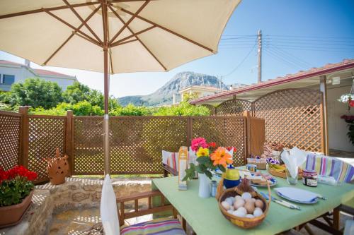 a table with an umbrella on a patio at Ancient Corinth Guest House in Kórinthos