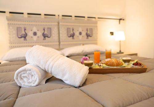 a hotel room with two beds with towels and a tray of food at I Fiori di Margherita Luxury B&B in Perugia