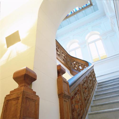 a staircase in a building with a wooden railing at Hospes Palau de La Mar, Valencia, a Member of Design Hotels in Valencia