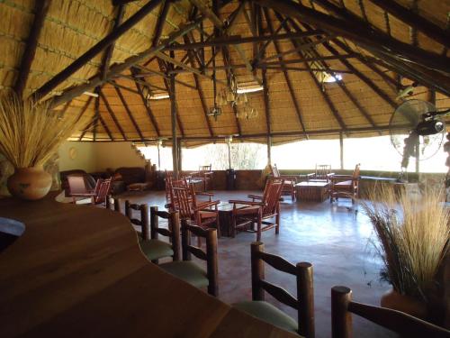 a restaurant with wooden chairs and tables in a building at Phokoje Bush Lodge in Selebi-Pikwe