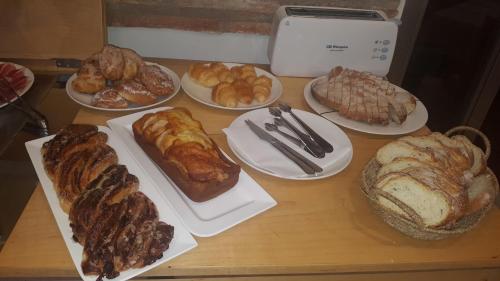 a table topped with different types of bread and pastries at La Merced de la Concordia in Tarazona de Aragón